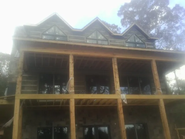 Dormers and porch framing on a large log home under construction — Roof Coating work by our crew in Duncannon