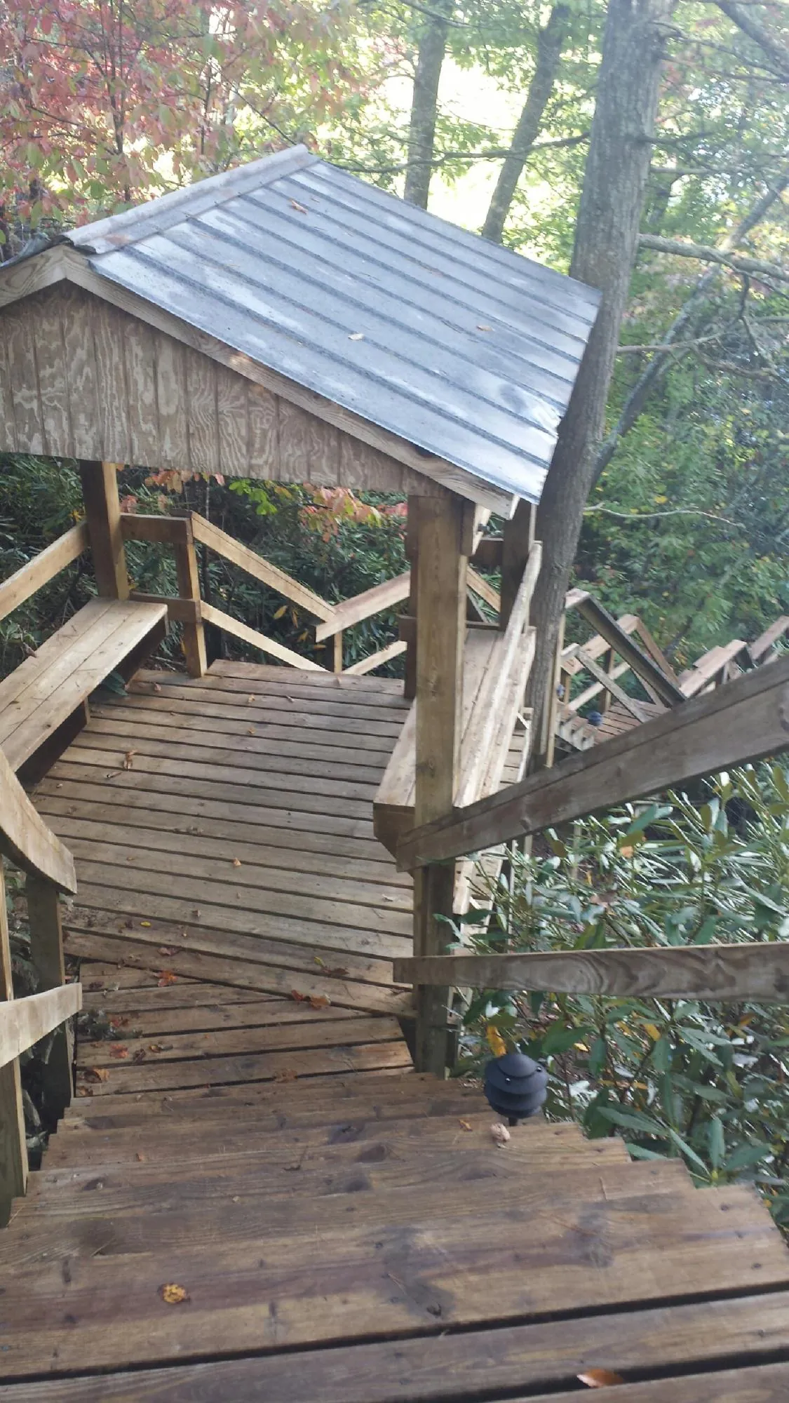 Metal roofed shelter over wooden steps on a wooded walkway — Skylight Repair & Installation work by our crew in Duncannon